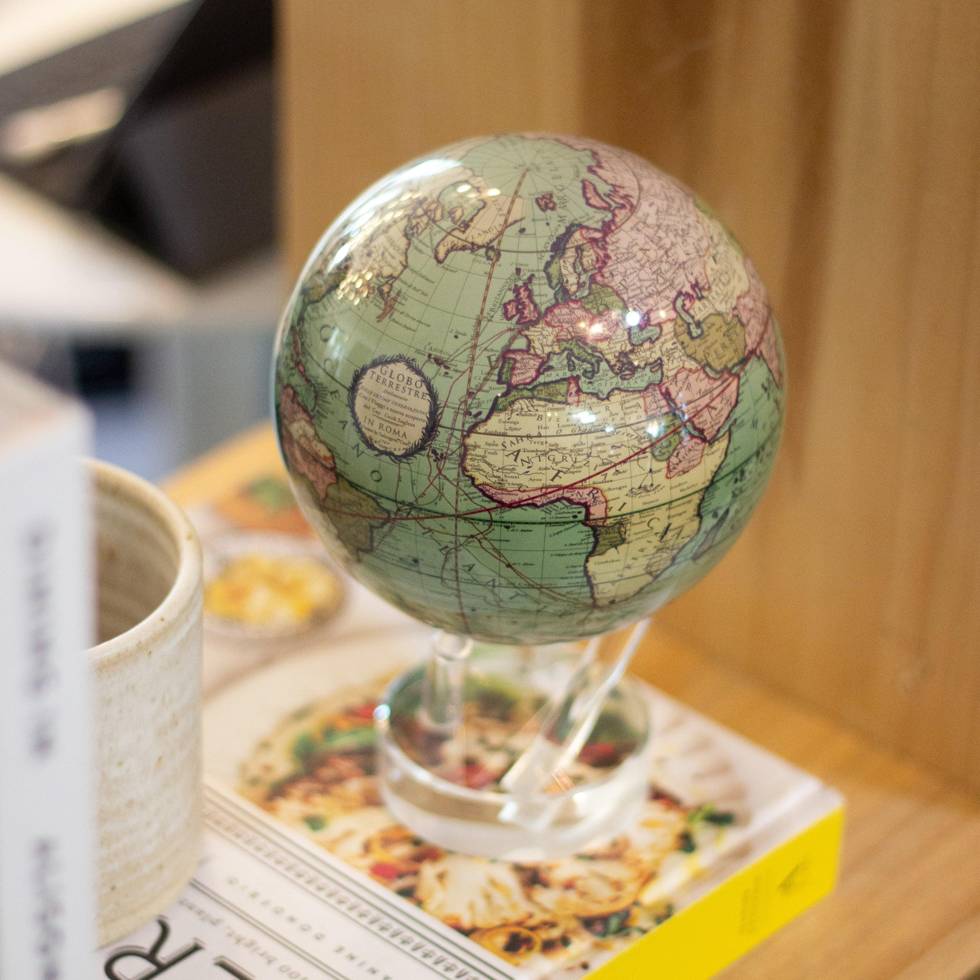 Cassini Green MOVA Globe styled with books on a wooden table
