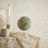 Antique Cassini Green MOVA Globe styled in a serene bedroom