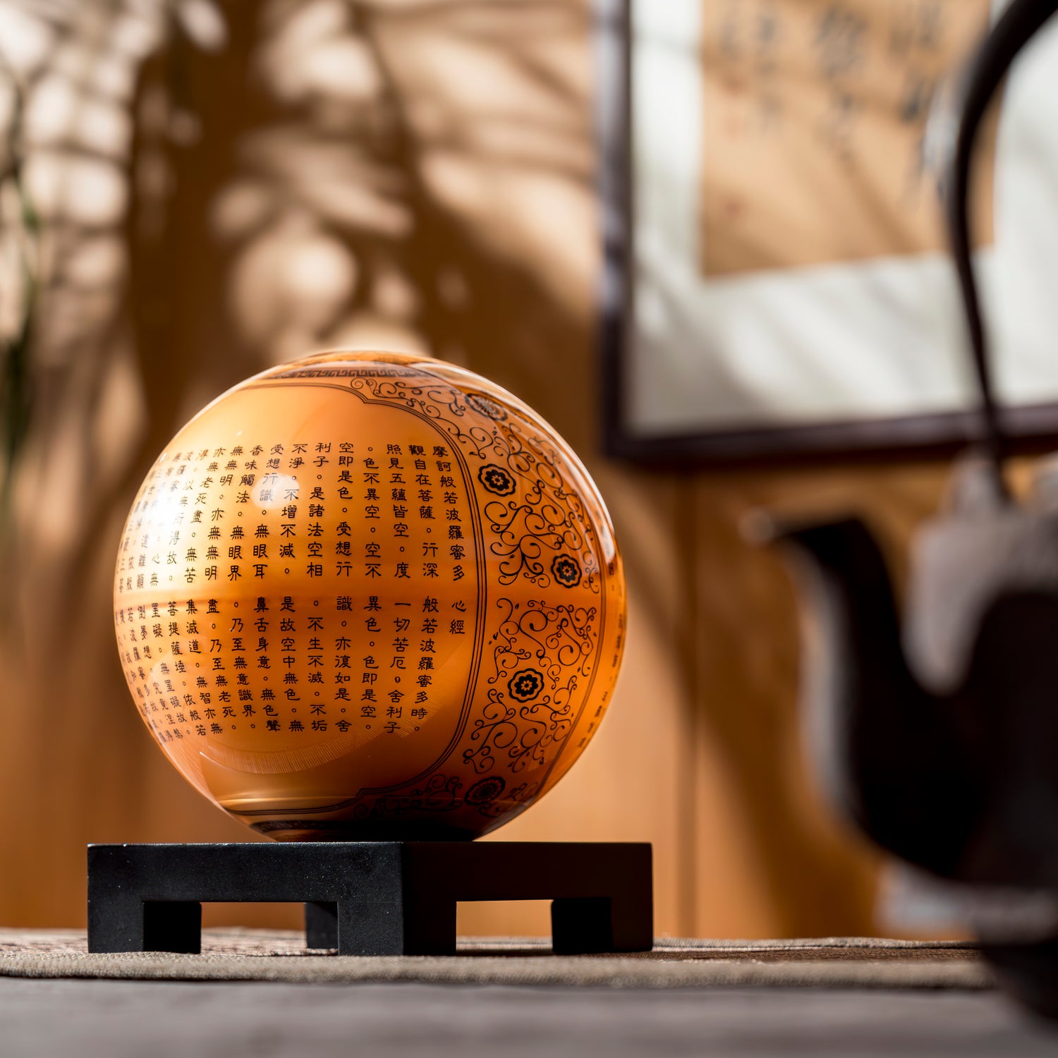 Illuminated HEART SUTRA GOLD GLOBE with inscriptions, displayed on square stand, a unique fusion of tradition and kinetic art.
