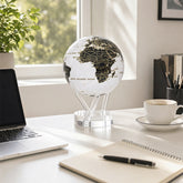 MOVA Globe on a bright workspace desk with laptop and notebook