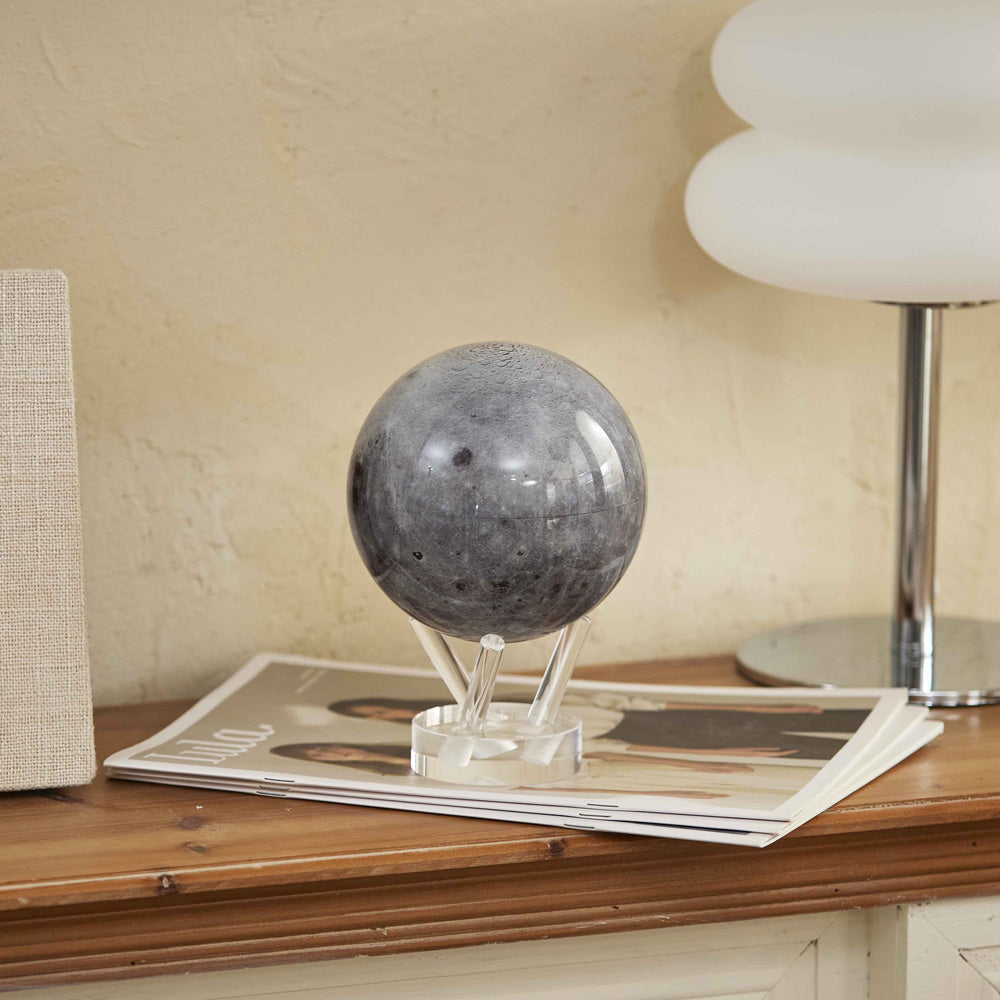 Moon MOVA Globe on console table beside magazines and lamp