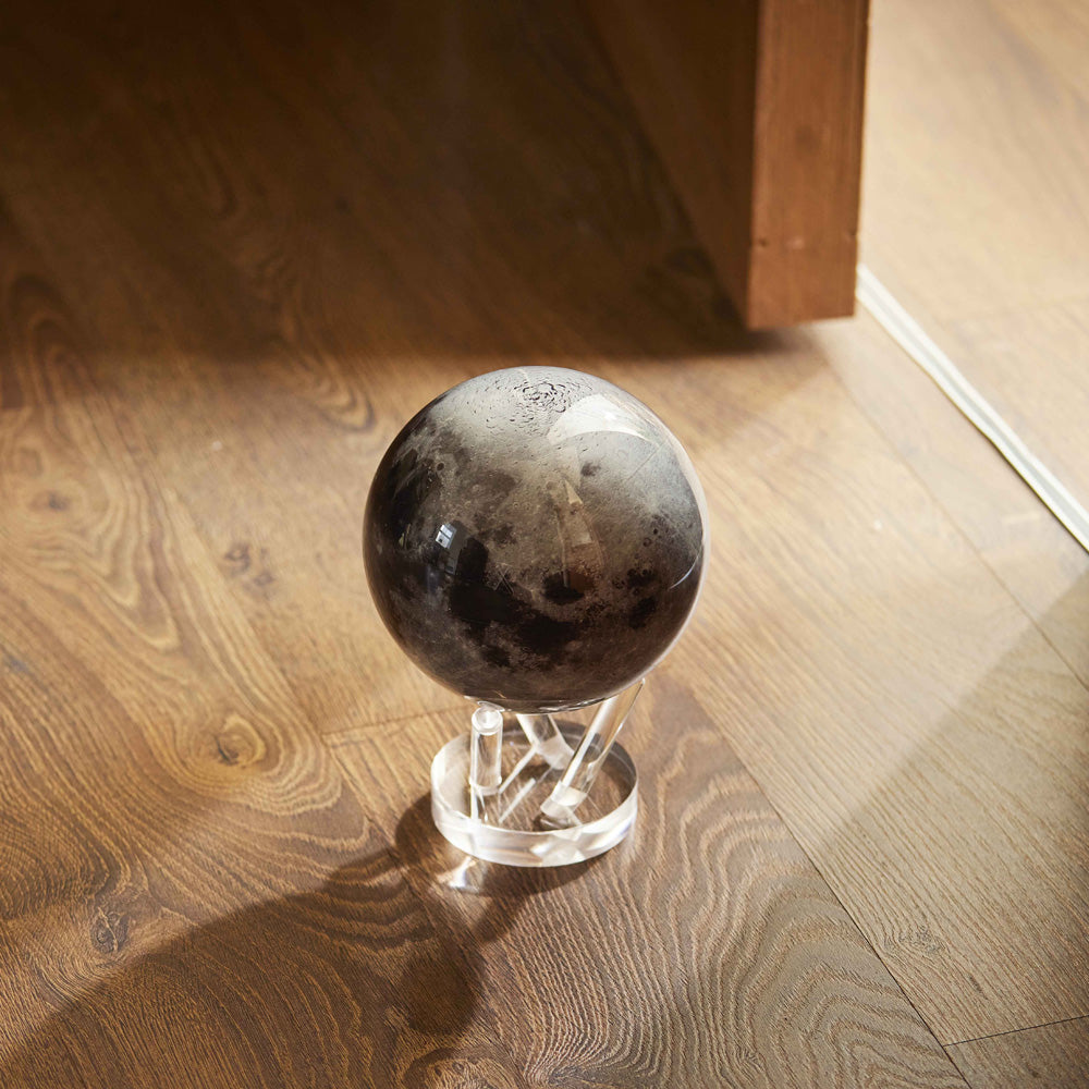 Moon MOVA Globe displayed on hardwood floor with acrylic base