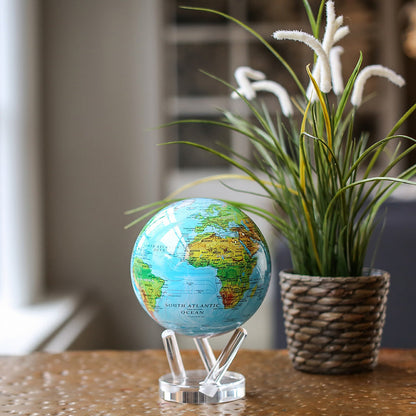Ocean blue MOVA Globe displayed beside a potted plant