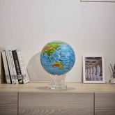 Colorful relief map MOVA Globe displayed with books and framed decor
